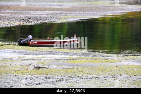 Alaska, Ketchikan, un garçon pêchant à marée basse à partir de la schiff. (M.) Banque D'Images