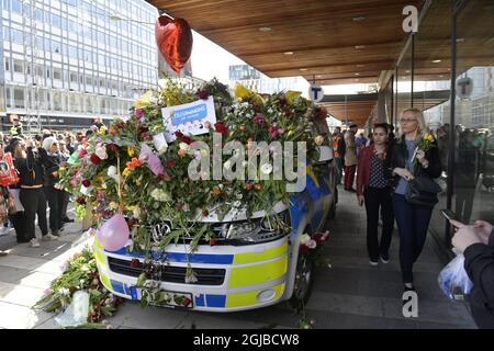 Un fichier photo daté du 09 avril 2017 montre une personne qui a mis des fleurs sur une voiture de police dans le centre de Stockholm, en Suède, près du site où un homme a conduit un camion dans une rue piétonne et dans un grand magasin à Stockholm, en Suède, tuant cinq personnes. L'auteur du crime, ouzbek Rakhmat Akilov, sera confronté à sa sentinelle aujourd'hui le 07 juin 2018. Photo: Jessica Gow / TT / code 10070 Banque D'Images