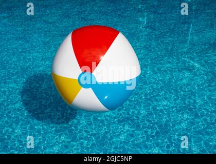 Ballon de plage gonflable flottant dans la piscine Banque D'Images