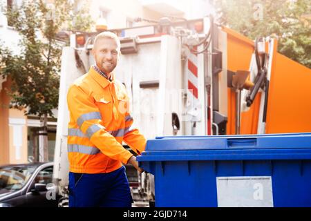 Enlèvement des ordures Homme effectuant la collecte des déchets et des ordures Banque D'Images