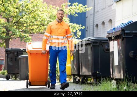 Enlèvement des ordures Homme effectuant la collecte des déchets et des ordures Banque D'Images