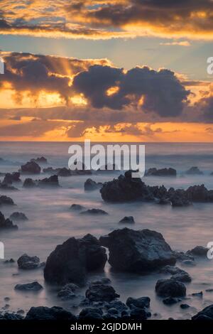 États-Unis, Hawaï, Big Island d'Hawaï. Parc de plage de Laupahoehoe point, lever du soleil sur les vagues et roche volcanique rugueuse. Banque D'Images