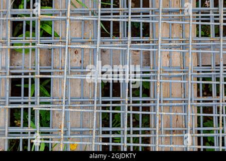 Treillis métallique utilisé dans la construction. Une maille métallique repose sur une palette en bois sur un chantier de construction. Banque D'Images