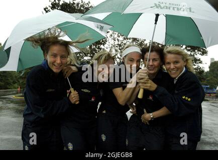 (G-D) Sofia Lundgren, Frida Ostberg, Hanna Marklund, Malin Mostrom et Anna Sjostrom, en Suède, se tenant à un parapluie à Washington. L'ouragan Isabel arrivera à Washington ce soir, heure locale. La coupe du monde des femmes commence le 20 avec le match d'ouverture de la Suède le 21. Banque D'Images