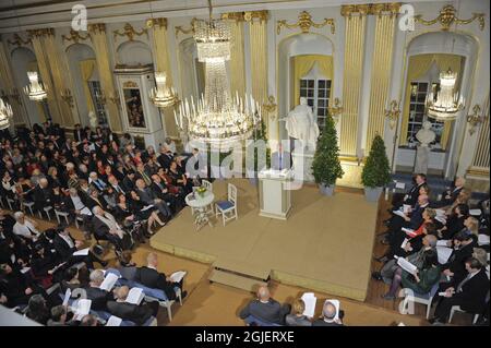 Mario Vargas Llosa tient sa conférence Nobel à l'Académie suédoise de la vieille ville de Stockholm, en Suède. Le prix Nobel de littérature 2010 est un citoyen péruvien et espagnol. Il recevra le prix Nobel vendredi. La statue derrière lui représente le roi Gustaf III, fondateur de l'académie. Banque D'Images