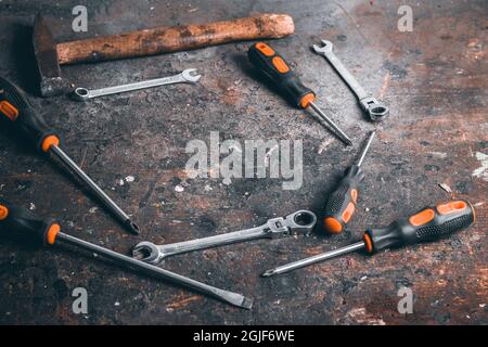 Tournevis, clés et marteau sur établi en bois.Vue de dessus des outils de travail avec espace pour le texte.Outils de construction sur table de travail en bois. Banque D'Images