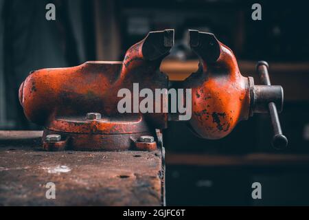 Rouge ancien étau. Un banc ou un outil de menuiserie pour fixer des pièces pour différents types de traitement (sciage, perçage, rabotage...). L'étau est monté sur une languette en bois Banque D'Images