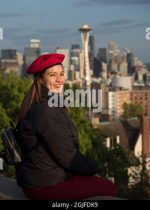 États-Unis, État de Washington, Seattle. Une jeune femme dans un béret rouge avec vue sur le centre-ville de Seattle et Space Needle. (M.) Banque D'Images