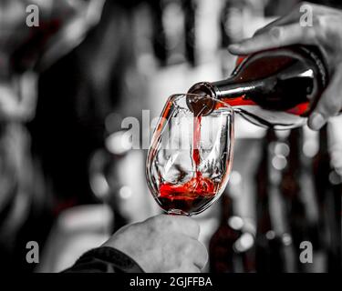 États-Unis, État de Washington, Seattle. Vin rouge versé dans un verre de vin lors d'une dégustation de vin. Banque D'Images
