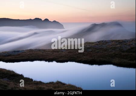 Les Langdale Pikes s'élevant au-dessus d'une inversion de nuages, à l'aube dans le district de English Lake Banque D'Images