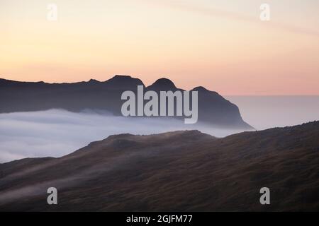 Les Langdale Pikes s'élevant au-dessus d'une inversion de nuages, à l'aube dans le district de English Lake Banque D'Images