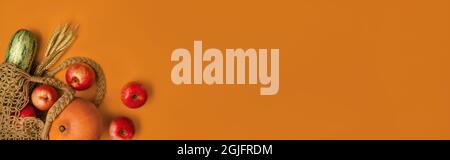 Sac en maille de coton avec fruits et légumes frais colorés sur fond orange. Concept de shopping et de mode de vie sain. Concept zéro déchet. Plan de présentation créatif avec emplacement pour le texte. Bannière Web. Banque D'Images