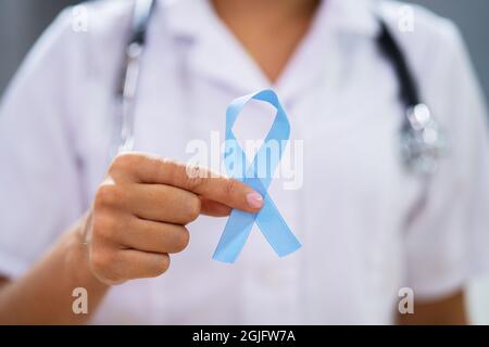 Médecin avec ruban bleu sarcelle de sensibilisation au cancer de l'ovaire à l'appui Banque D'Images