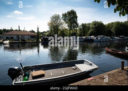 Une vue sur les Norfolk Broads à la rivière Green Thorpe Saint Andrew avec des bateaux amarrés le long de la rive lors d'une journée ensoleillée d'été Banque D'Images