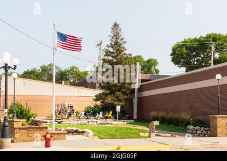 Chamberlain, Dakota du Sud, USA-24 AOÛT 2021 : petit parc de la ville avec chevaux de passe-temps, appareil d'escalade pour enfants en wagon et mât de drapeau. Banque D'Images