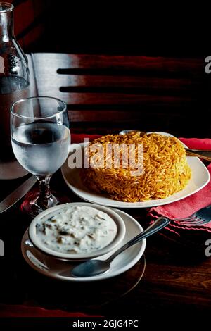 Riz biryani de poulet indien épicé à la raita fraîche Banque D'Images