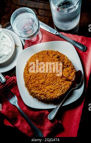 Riz biryani de poulet indien épicé à la raita fraîche Banque D'Images