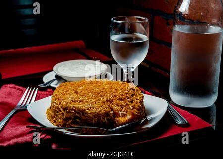 Riz biryani de poulet indien épicé à la raita fraîche Banque D'Images