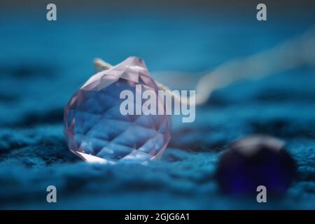 Grand cristal rose sur une table bleue tricotée. Banque D'Images