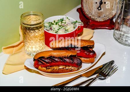 Sous-sandwich à la saucisse de kielbasa grillé au charbon de bois avec sauce à la déesse verte et salade de pommes de terre Banque D'Images