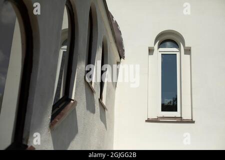 Fenêtres dans l'ancien temple. Église orthodoxe russe. Ancien bâtiment. Murs blanchis à la chaux. Petites fenêtres dans un mur plein. Banque D'Images