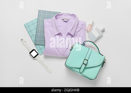 Accessoires féminins élégants, chemise et montre intelligente moderne sur fond blanc Banque D'Images