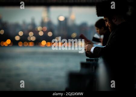 New York, New York, États-Unis. 8 septembre 2021. New York, New York, États-Unis. 8 septembre 2021.Un homme hassidique raconte la prière de Tashlich par la rivière East dans le sud de Williamsburg, Brooklyn, le mercredi 8 septembre 2021 à New York, USA.Tashlich est un rituel d'expiation exécuté entre le nouvel an juif de Rosh Hashanah et Yom Kippour. Au cours de cette cérémonie, les Juifs ont symboliquement rejeté les péchés de l'année précédente en lançant des cailloux ou des miettes de pain dans l'eau courante.Credit: Stefan Jeremiah/ZUMA Wire (Credit image: © Stefan Jeremiah/ZUMA Press Wire) Banque D'Images