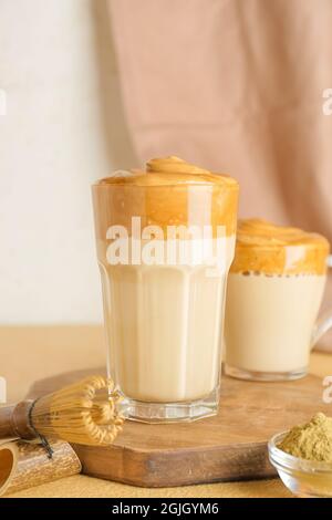 Verre et tasse de délicieux Dalgona hojicha latte sur la table Banque D'Images