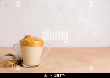 Tasse en verre de délicieux Dalgona hojicha latte et chasen sur table Banque D'Images