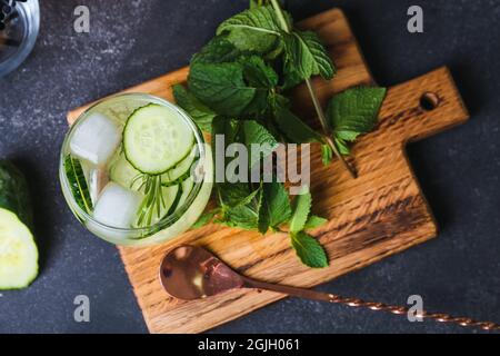 Verre de tonique de gin froid et tranches de concombre sur fond sombre Banque D'Images