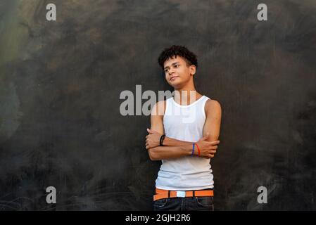 Afro latin homme adolescent contre un mur, regardant vers le haut. Banque D'Images