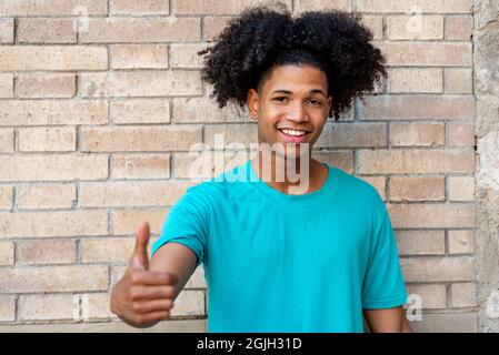 Jeune Afro latin homme souriant contre un mur Banque D'Images