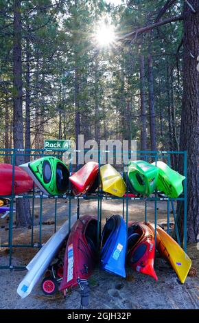 VILLAGE INCLINÉ, NV –11 APR 2021- des casiers de kayaks et planches de surf colorés dans les bois sur la rive du lac Tahoe. Banque D'Images