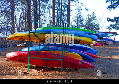 VILLAGE INCLINÉ, NV –11 APR 2021- des casiers de kayaks et planches de surf colorés dans les bois sur la rive du lac Tahoe. Banque D'Images