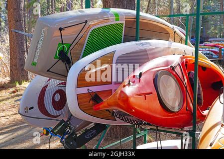 VILLAGE INCLINÉ, NV –11 APR 2021- des casiers de kayaks et planches de surf colorés dans les bois sur la rive du lac Tahoe. Banque D'Images