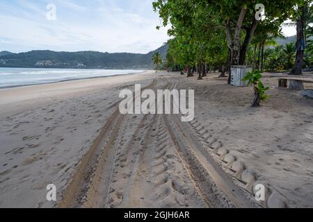 Pistes de pneus 4x4 sillonnantes pistes de pneus sur fond de sable à la plage de Patong Phuket en Thaïlande. Banque D'Images