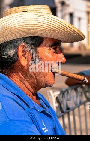 Portrait d'un homme cubain portant un chapeau de cow-boy en paille et fumant un cigare, Sancti Spiritus, Cuba Banque D'Images