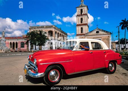 Chauffeur de taxi avec voiture classique américaine 1951 Plymouth, Parque Marti, Remedios, Cuba Banque D'Images