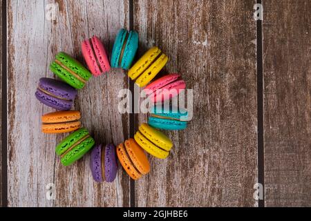 Délicieux macarons, un célèbre dessert français multicolore dans un cercle. Mise au point sélective. Arrière-plan flou Banque D'Images