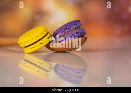 Délicieux macarons, un célèbre dessert français multicolore avec une cuillère en bois. Mise au point sélective. Arrière-plan flou Banque D'Images