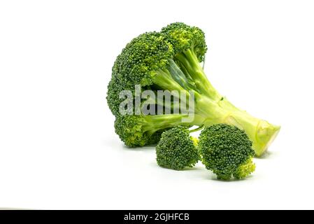 Gros plan sur le brocoli entier frais et couper le brocoli sur fond blanc. Vue latérale brocoli, entier, et coupé en petits morceaux. Banque D'Images
