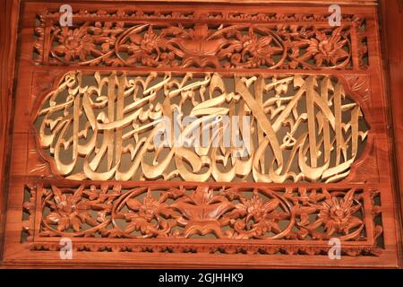 Un chef-d'œuvre de tentures murales sculptées et de portes en bois avec le lettrage artistique arabe des ornements de calligraphie. Banque D'Images