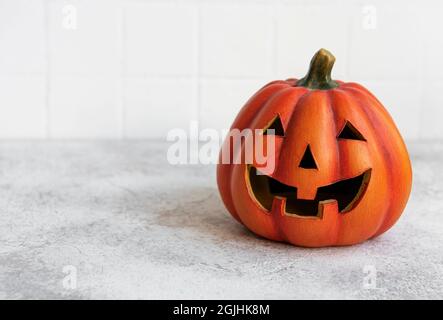 Citrouille Jack-O-Lanterne avec visage heureux. Citrouille d'Halloween souriante sur fond de béton. Carte de voeux pour Halloween. Banque D'Images