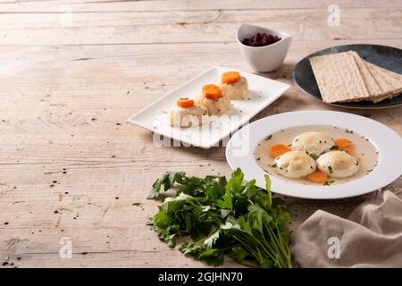Soupe juive traditionnelle de matzah, poisson gefilte et pain de matzah sur une table en bois Banque D'Images