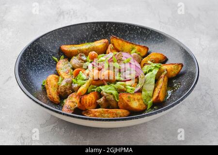 Quartiers de pommes de terre frits avec champignons vêtus d'oignons rouges et blancs Banque D'Images