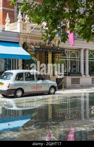 Un portier en uniforme accueille un taxi arrivant devant l'entrée principale de l'hôtel Connaught, Mayfair, Londres, Angleterre, Royaume-Uni Banque D'Images