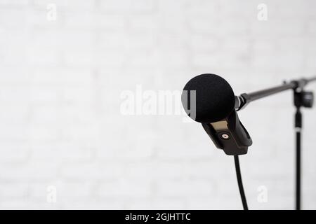 podcast, enregistrement vocal et blogging concept - microphone moderne sur fond de mur de brique blanche avec espace de copie Banque D'Images