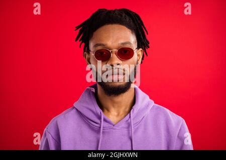 Photo portrait homme portant lunettes de soleil grave isolé couleur rouge vif arrière-plan Banque D'Images