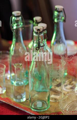 Vider les bouteilles vertes vintage et les verres en cristal sur la table Banque D'Images