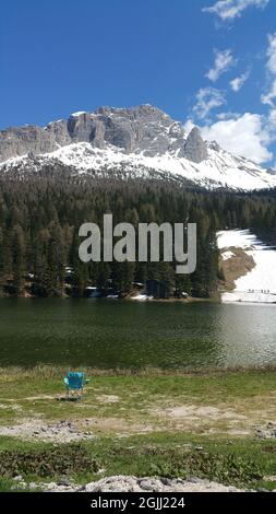 Misurina, Italie - 31 mai 2021 : le fabuleux lac alpin dans les Dolomites. Chaise sur la rive. Un endroit charmant et reposant dans les Alpes italiennes Banque D'Images